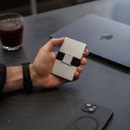 Platinum Evolve Smart Wallet held in hand near MacBook and coffee
