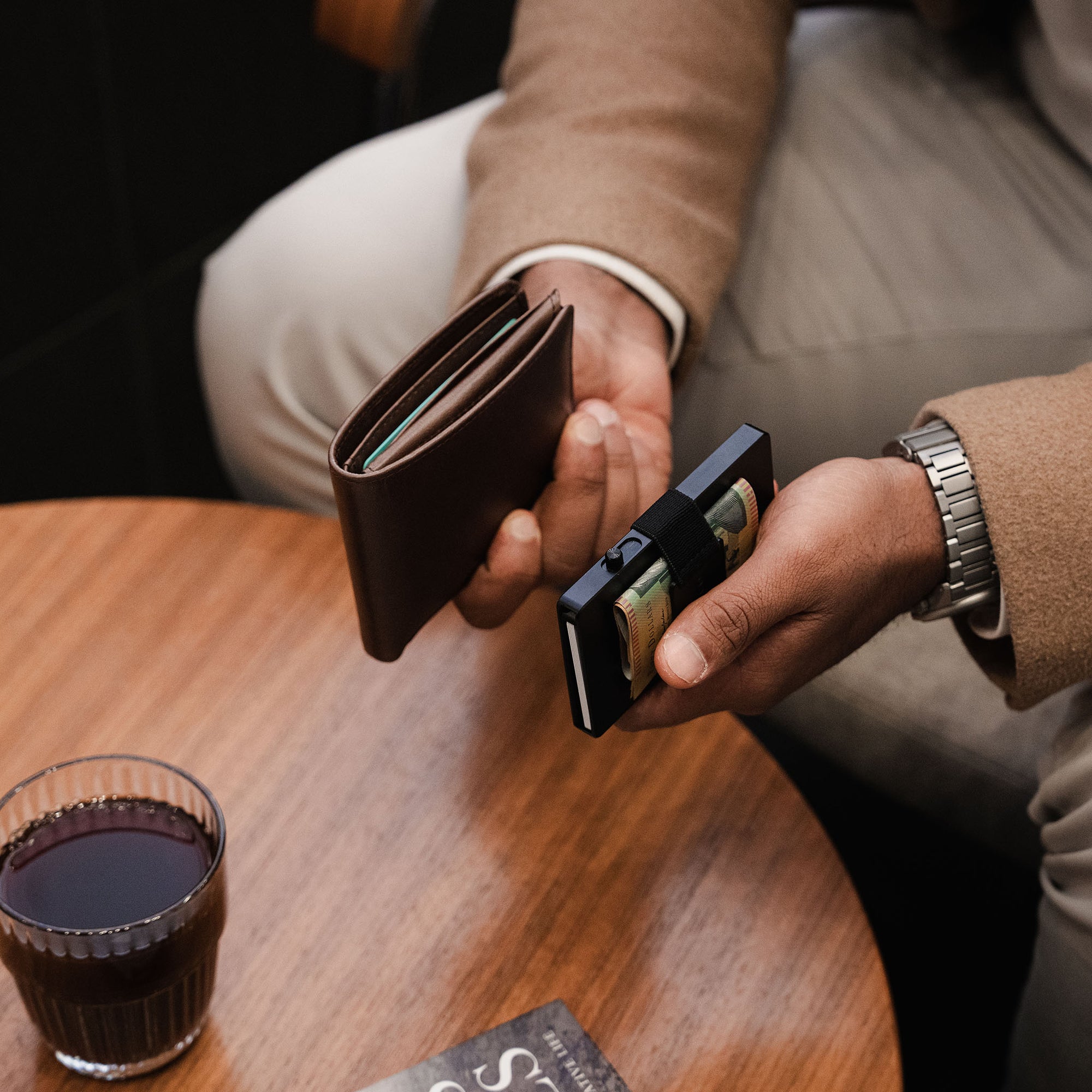 Midnight Black Evolve wallet and Vault Key Case on café table