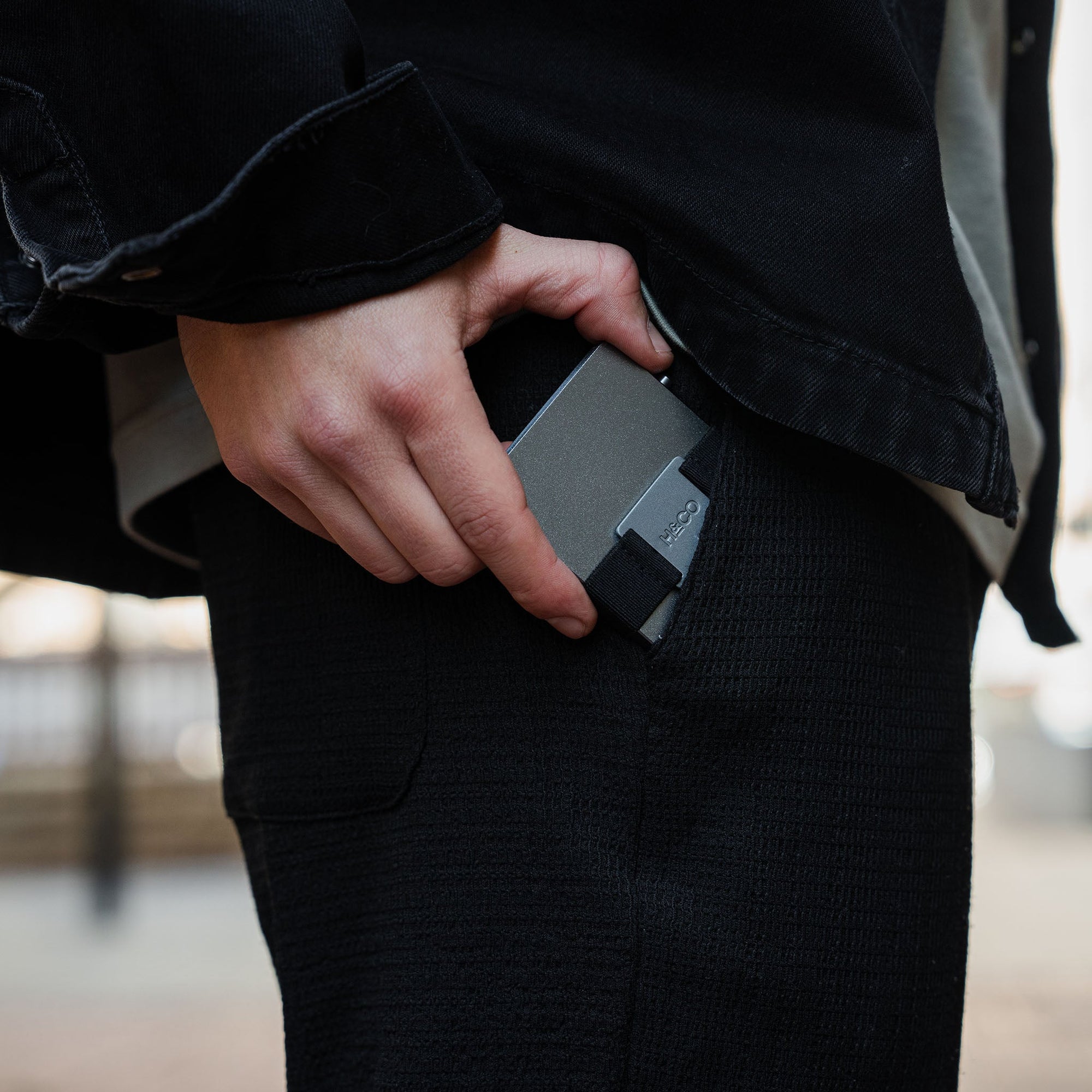 Steel Blue wallet being pulled from pants pocket in stylish streetwear setting