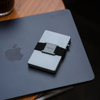 Steel Blue Evolve Smart Wallet resting on MacBook in workspace setting