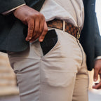 Man wearing cream chinos placing Midnight Black wallet in front pocket