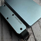 Close-up detail of Vault Key Case in Steel Blue resting beside Evolve Smart Wallet