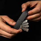 Midnight Black Vault Key Case in hand with keys being deployed