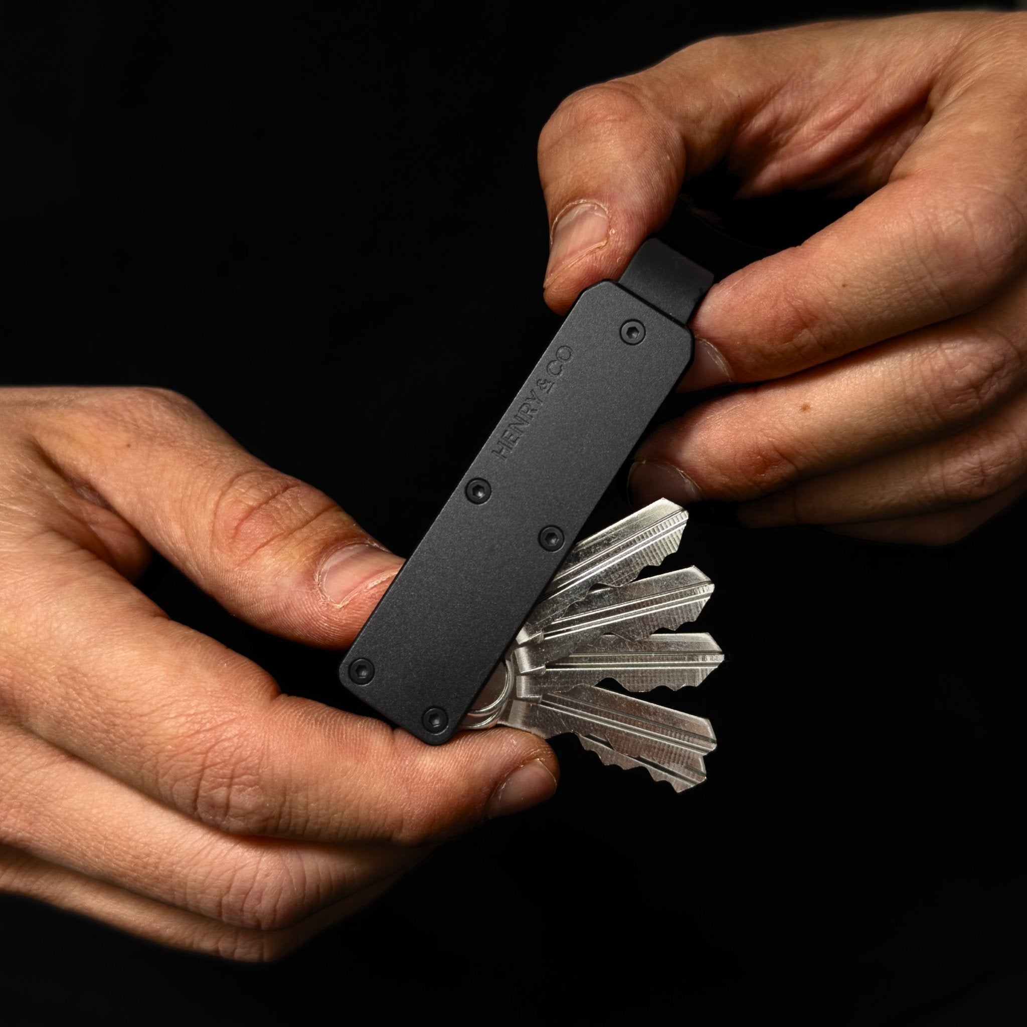 Midnight Black Vault Key Case in hand with keys being deployed